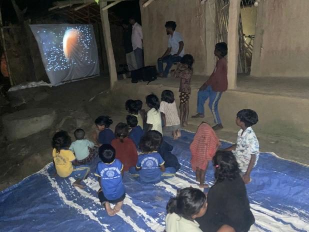 Children watching the Jesus Film projected in a village at night